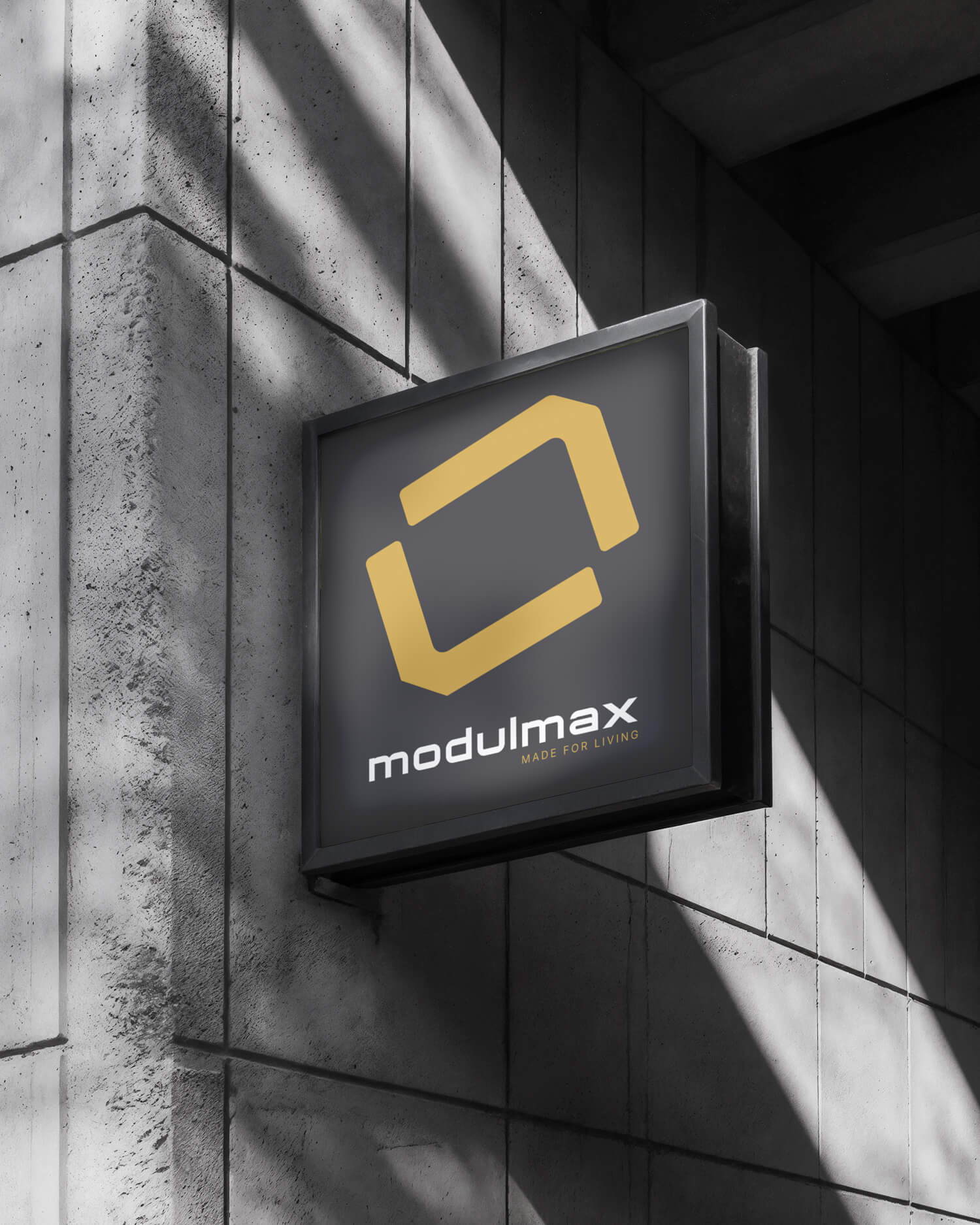 Svetelná tabuľa s logom MODULMAX na betónovej fasáde – firemné označenie